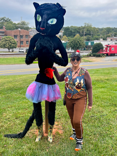 Karen Duquette and a big black cat scarecrow