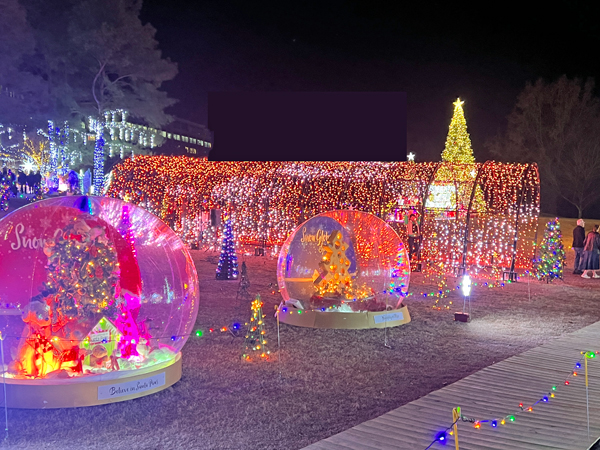 Two snow globes by the lighted tunnel