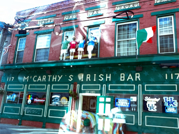 4 statues of people standing on the ledge