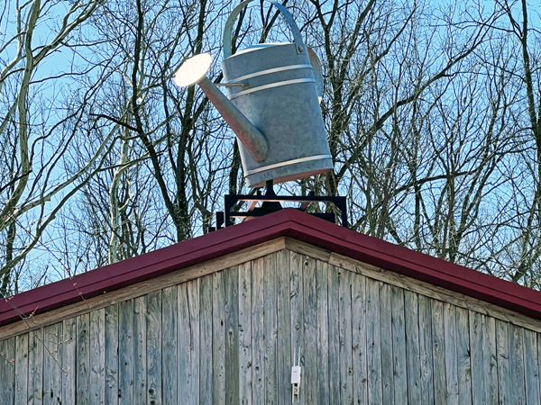 garden shop with a giant rooftop watering can on the roof