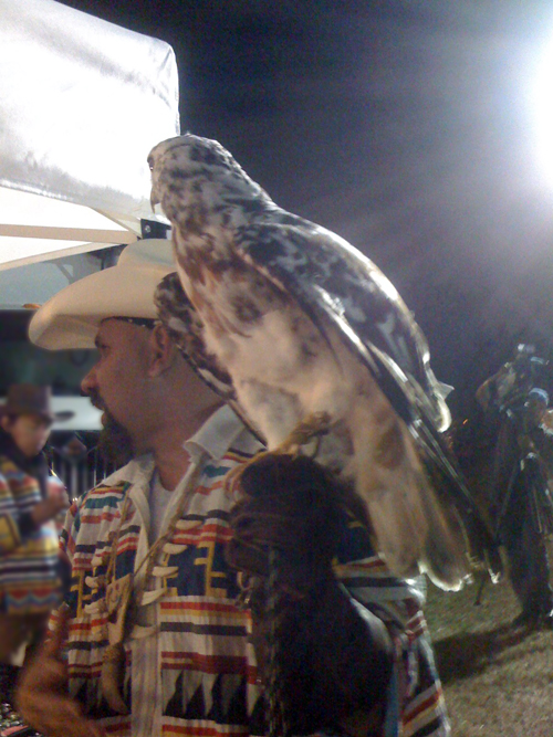 man in a cowboy hat was walking around with a big bird