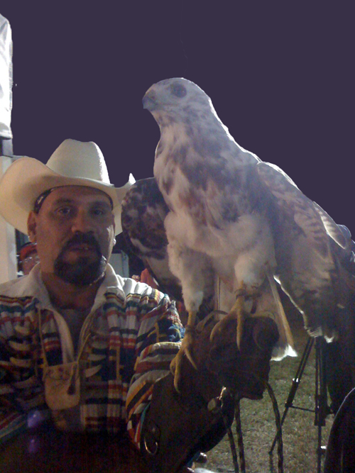 man in a cowboy hat was walking around with a big bird