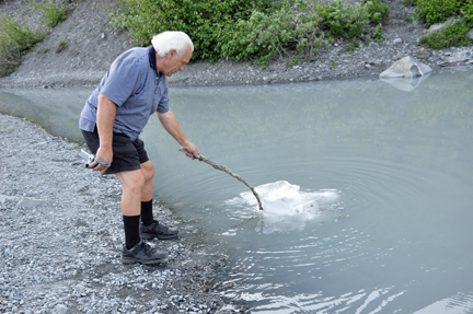 Lee Duquette playing with a piece of ice at Valdez Glacier