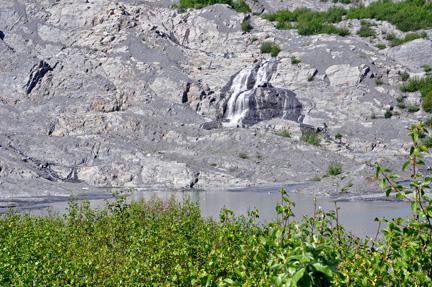 a small waterfall on the other side of the lake