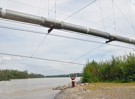 Karen Duquette standing under the Alaska Pipeline 2009