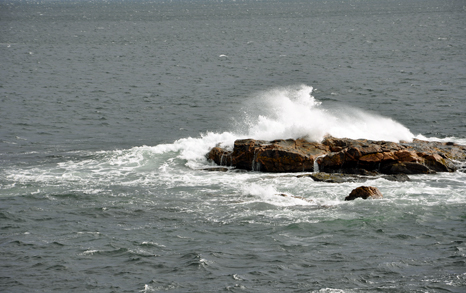 waves pounding boulders in the ocean