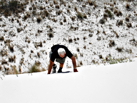 Lee Duquette climbing up the white sand dune