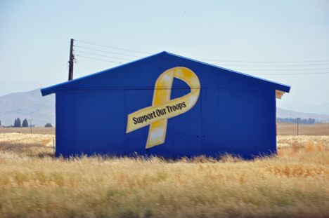 a farm building with a  note to support our troops