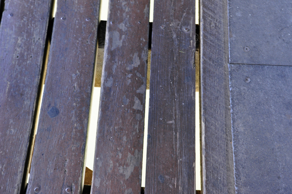 looking down through the slats on the floor of the covered bridge