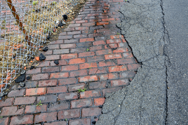 Concrete was poured over the brick sidewalk