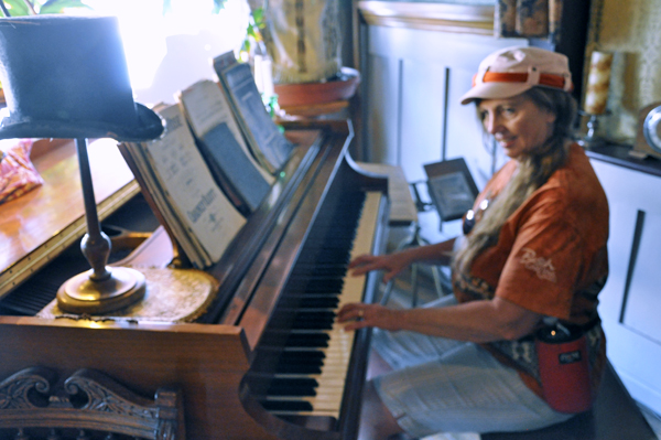 Karen Duquette playing a piano inside the Occidental Hotel