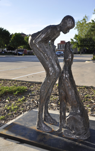 man and dog sculpture